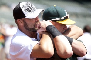UFC fighter Randy Couture (left) demonstrates a choke hold on Oakland Athletics first baseman Daric Barton (right) before the game against the Texas Rangers at Oakland-Alameda County Coliseum. Mandatory Credit: Jason O. Watson-USA TODAY Sports