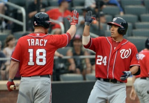  Washington Nationals catcher Kurt Suzuki (24) high fives first baseman Chad Tracy (18) after his two-run home run in the 8th inning against the New York Mets at Citi Field. Mandatory Credit: Robert Deutsch-USA TODAY Sports